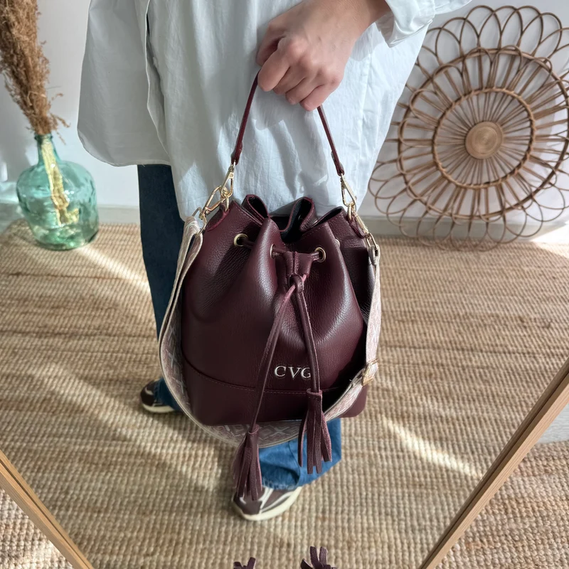 Bolso bucket piel granate grande pompón iniciales bordadas