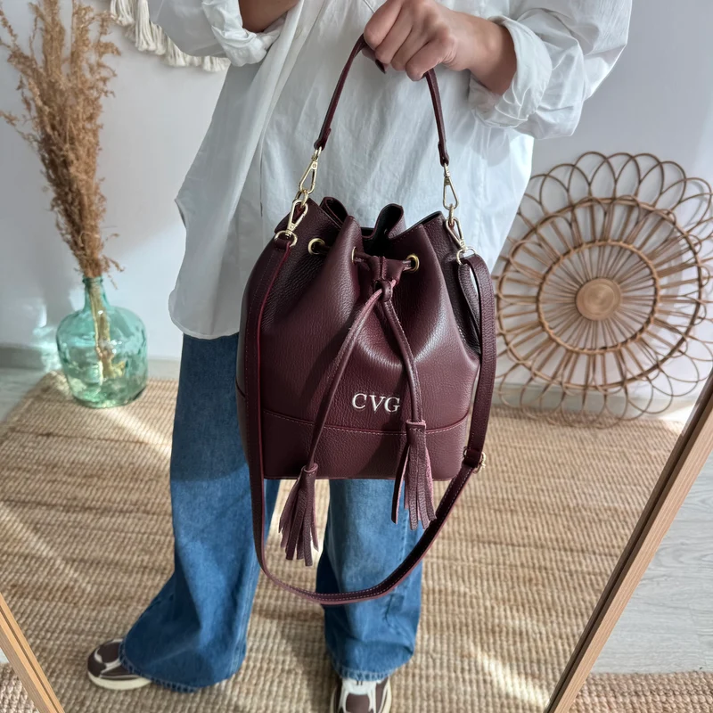 Bolso bucket piel granate grande pompón iniciales bordadas
