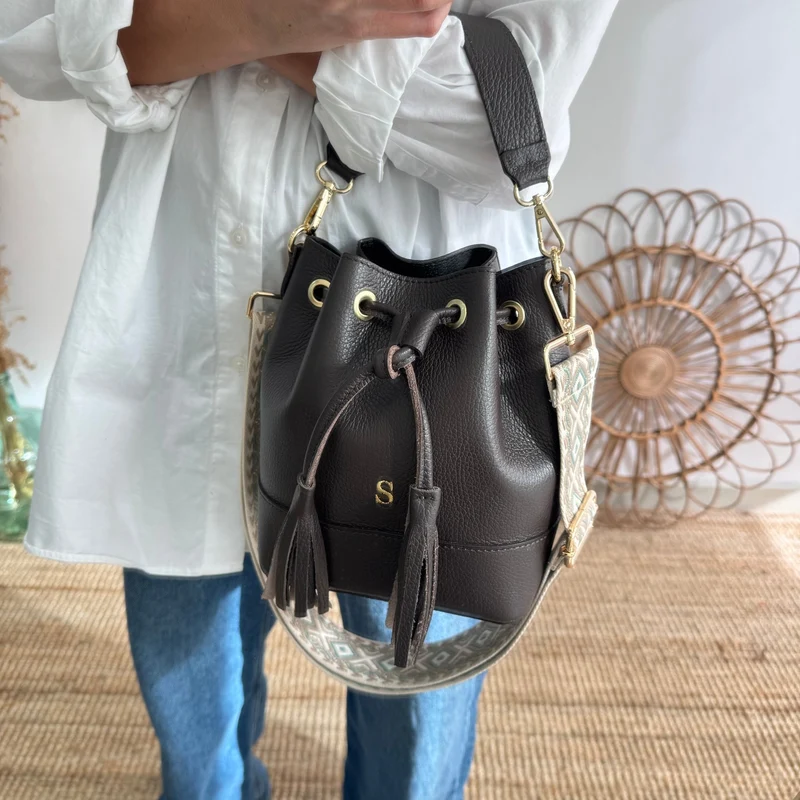 Bolso bucket piel marrón pompón iniciales bordadas