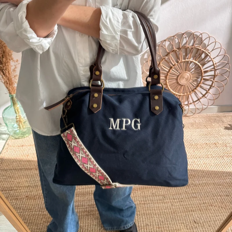 Bolso combinado loneta y piel azul marino iniciales bordadas con correa étnica