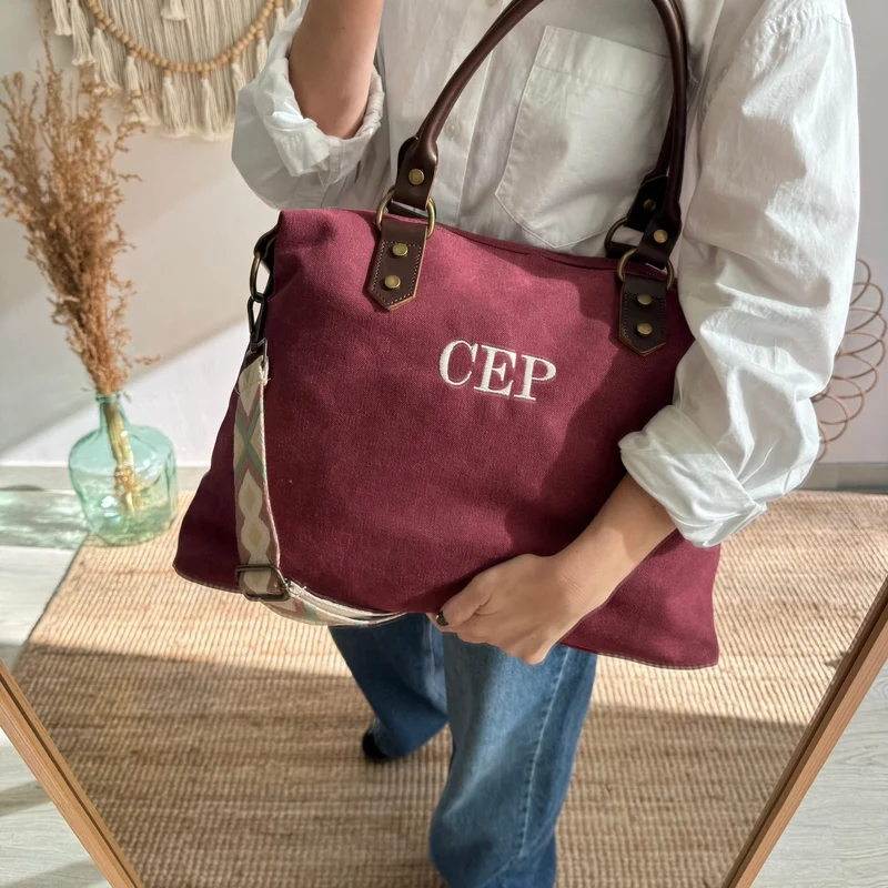 Bolso combinado loneta y piel granate iniciales bordadas con correa étnica