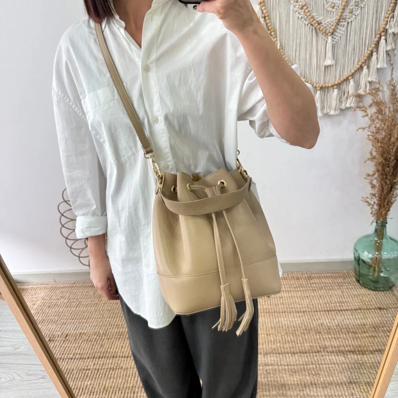 Bolso bucket piel taupe grande pompón iniciales bordadas