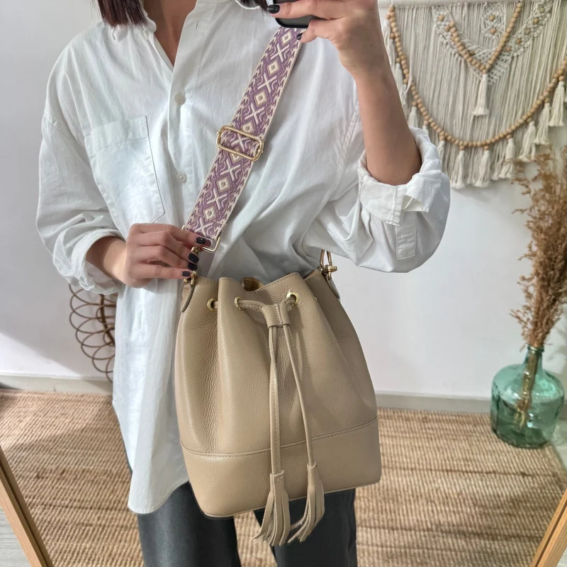 Bolso bucket piel taupe grande pompón iniciales bordadas