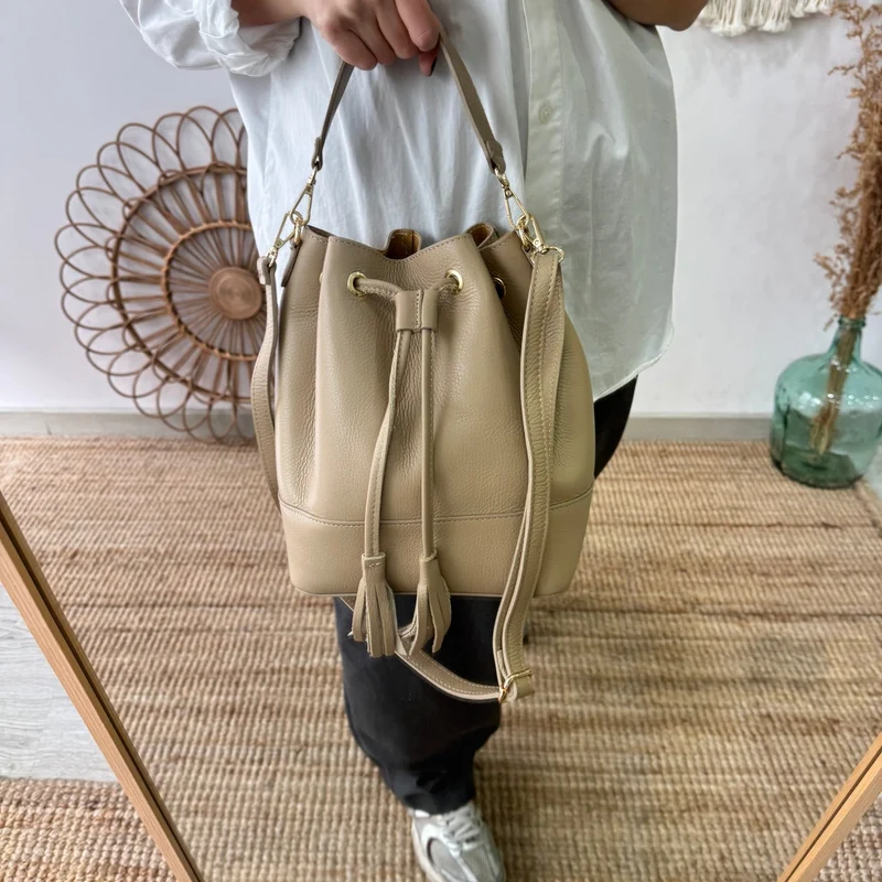 Bolso bucket piel taupe grande pompón iniciales bordadas