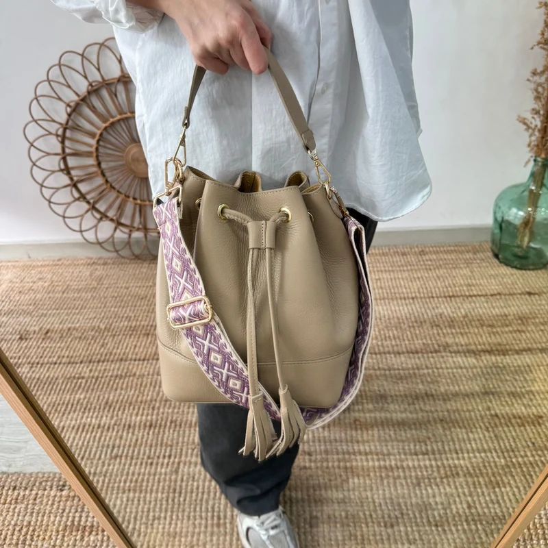 Bolso bucket piel taupe grande pompón iniciales bordadas
