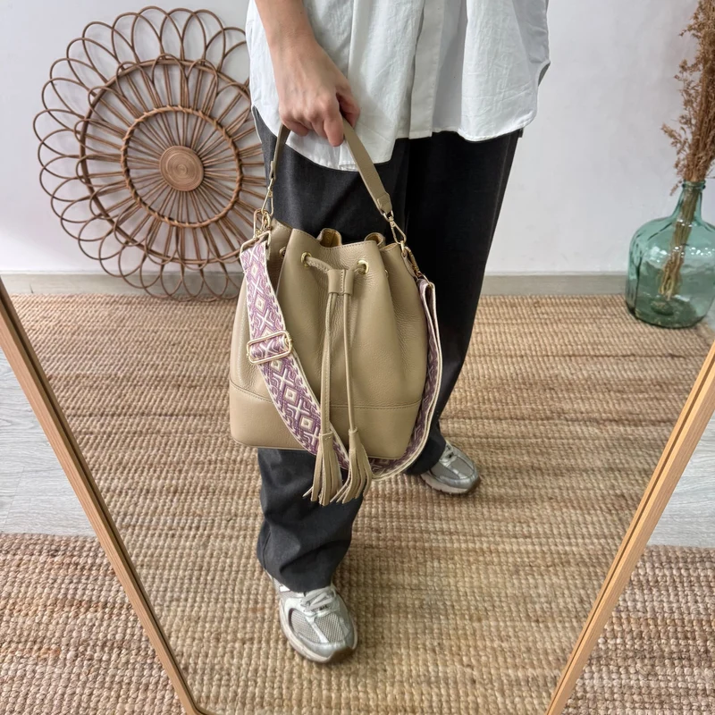 Bolso bucket piel taupe grande pompón iniciales bordadas