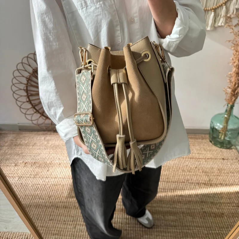 Bolso bucket combinado serraje y piel taupe pompón iniciales bordadas
