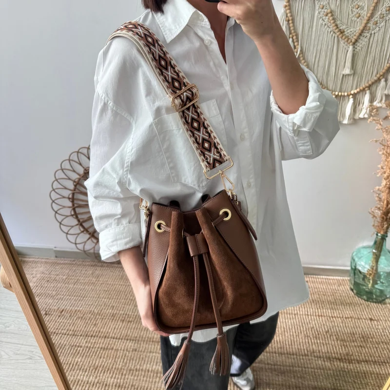 Bolso bucket combinado serraje y piel marrón pompón iniciales bordadas