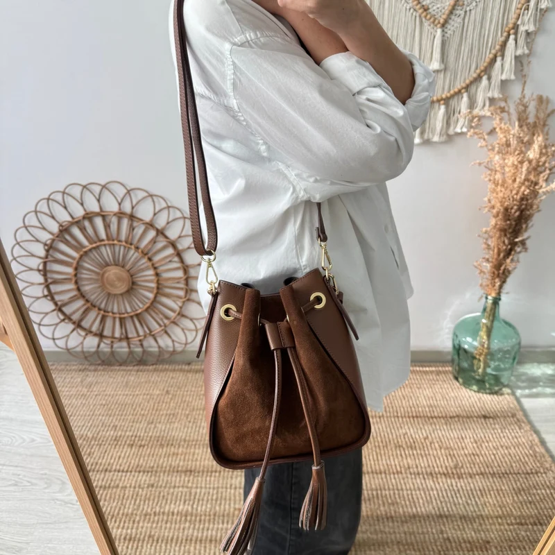 Bolso bucket combinado serraje y piel marrón pompón iniciales bordadas