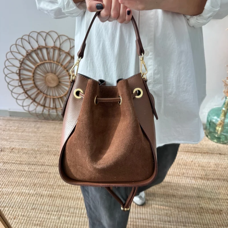 Bolso bucket combinado serraje y piel marrón pompón iniciales bordadas