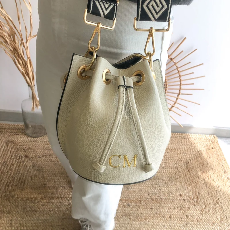 Bombonera piel beige arandelas doradas iniciales bordadas