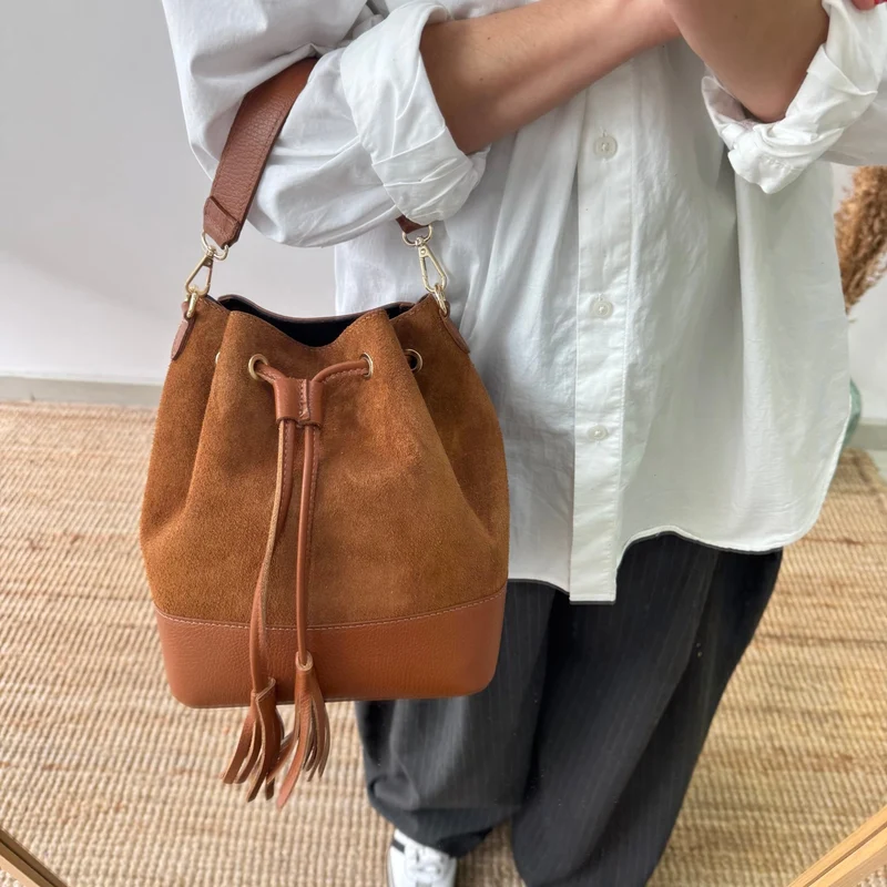 Bolso bucket serraje y piel camel grande pompón iniciales bordadas
