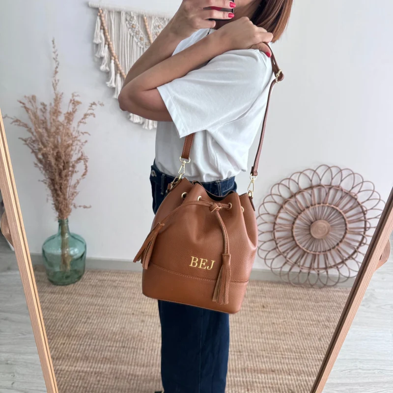 Bolso bucket piel camel grande pompón iniciales bordadas
