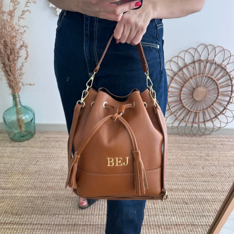 Bolso bucket piel camel grande pompón iniciales bordadas