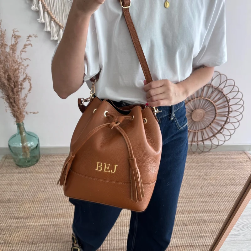 Bolso bucket piel camel grande pompón iniciales bordadas