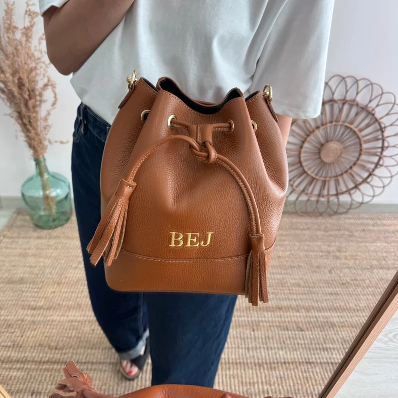 Bolso bucket piel camel grande pompón iniciales bordadas