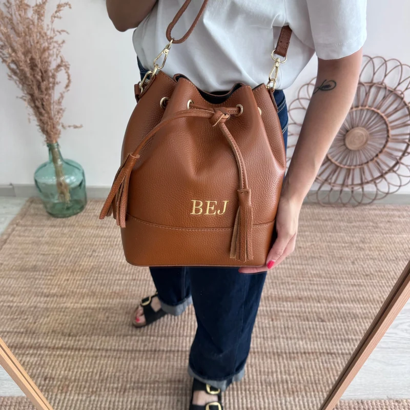 Bolso bucket piel camel grande pompón iniciales bordadas