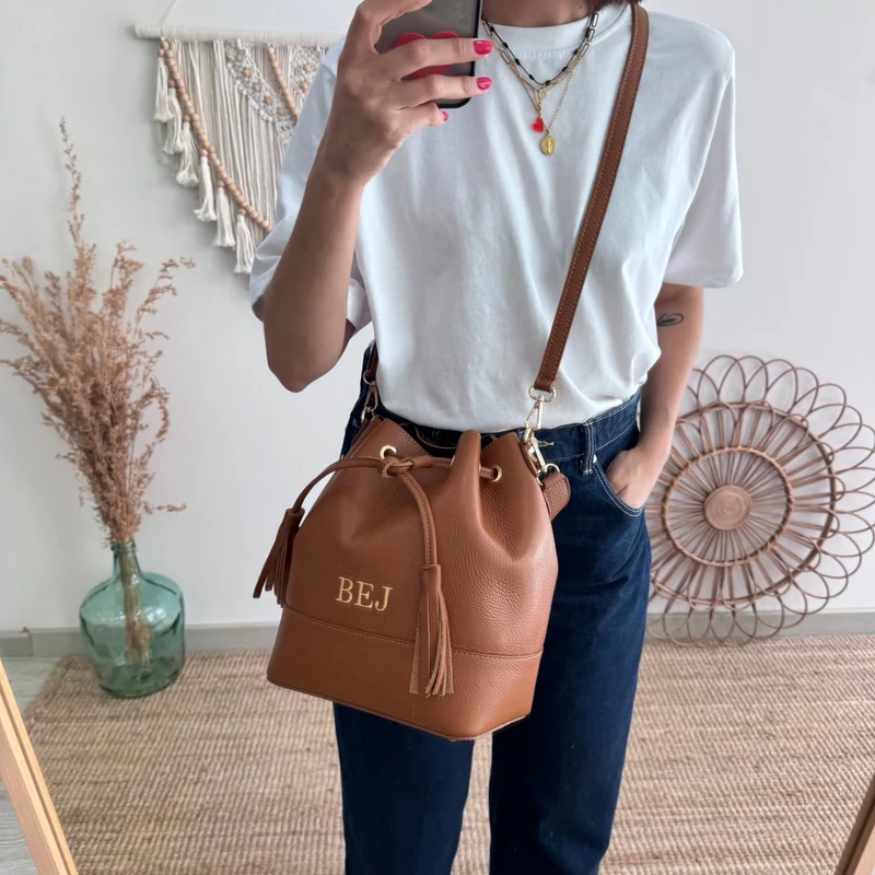 Bolso bucket piel camel grande pompón iniciales bordadas