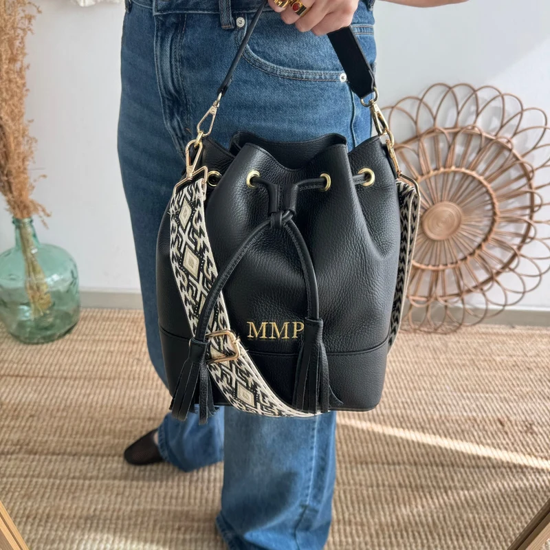 Bolso bucket piel negro grande pompón iniciales bordadas
