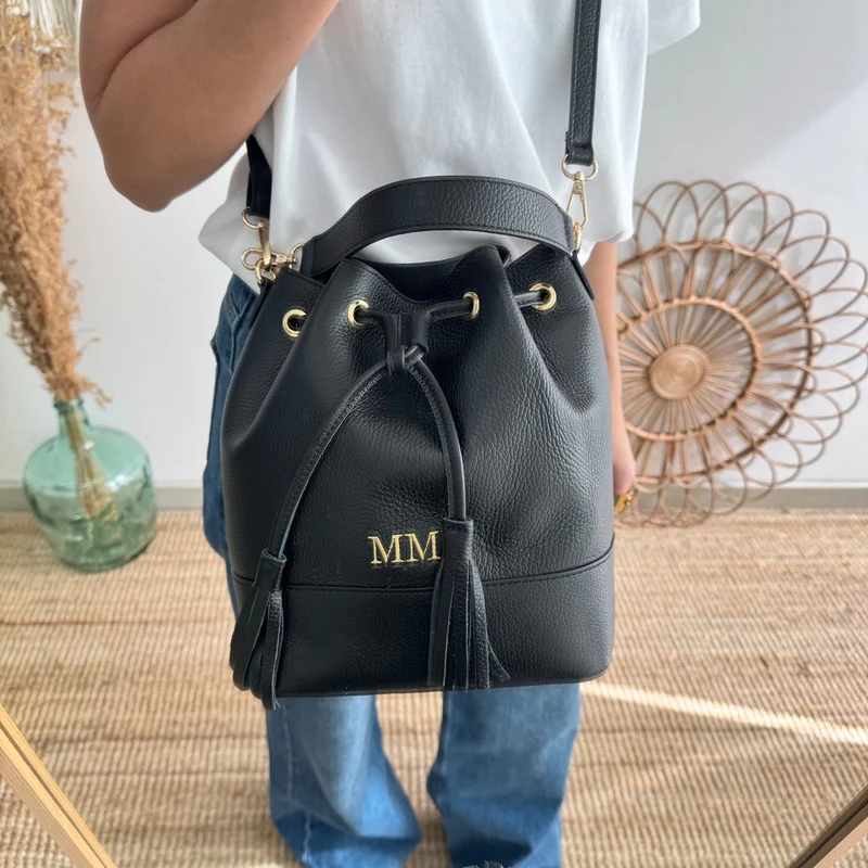 Bolso bucket piel negro grande pompón iniciales bordadas