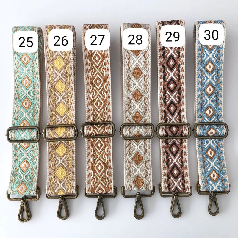 Bandolera ovalada piel tachuelas negra iniciales bordadas herrajes cobre