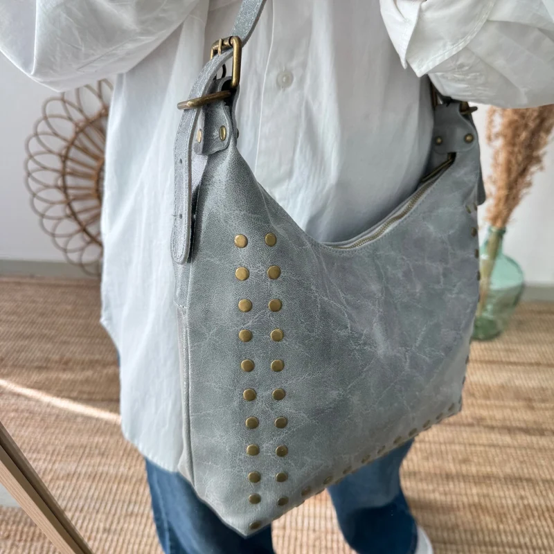 Bolso tachuelas piel gris claro iniciales bordadas