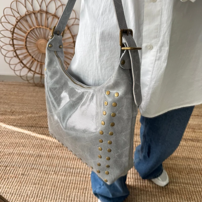 Bolso tachuelas piel gris claro iniciales bordadas