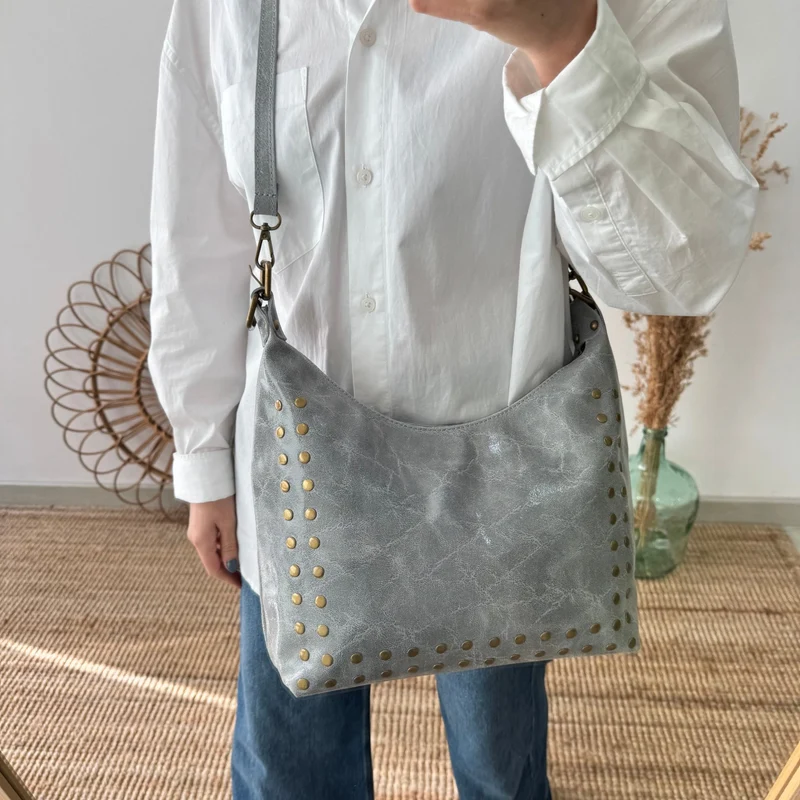 Bolso tachuelas piel gris claro iniciales bordadas