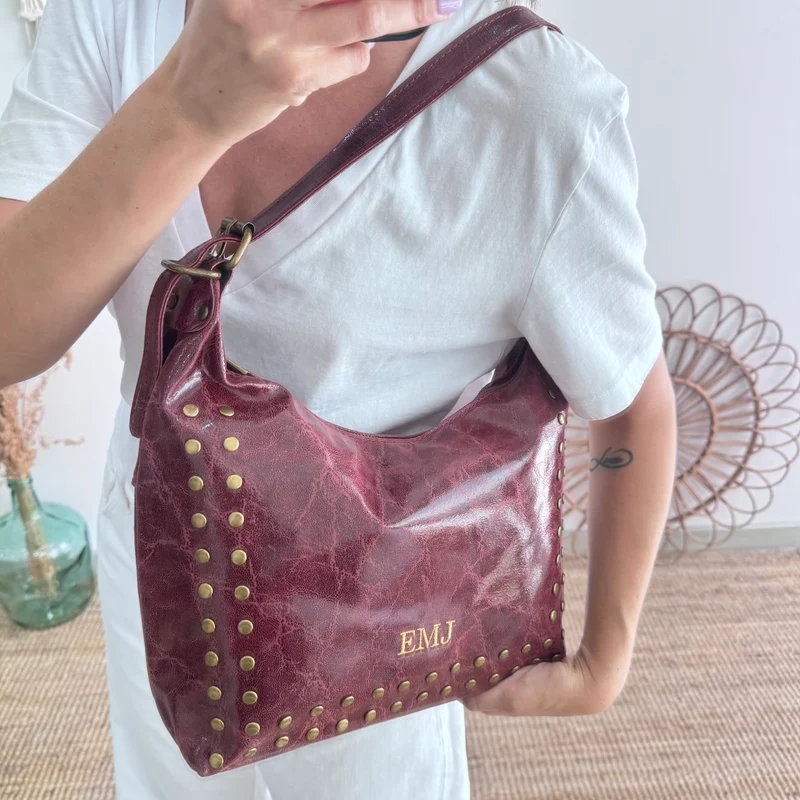 Bolso tachuelas piel granate iniciales bordadas