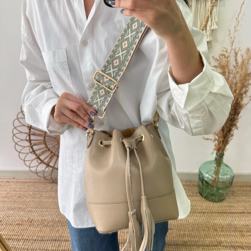 Bolso bucket piel taupe pompón iniciales bordadas