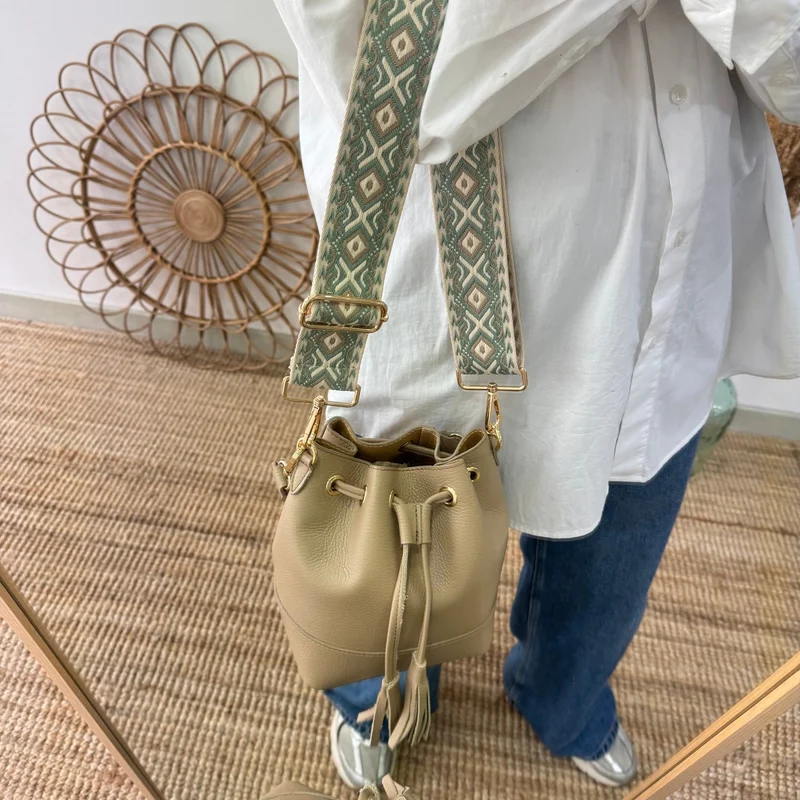 Bolso bucket piel taupe pompón iniciales bordadas