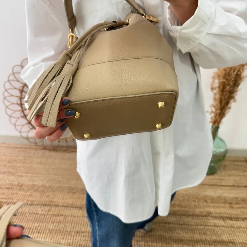 Bolso bucket piel taupe pompón iniciales bordadas