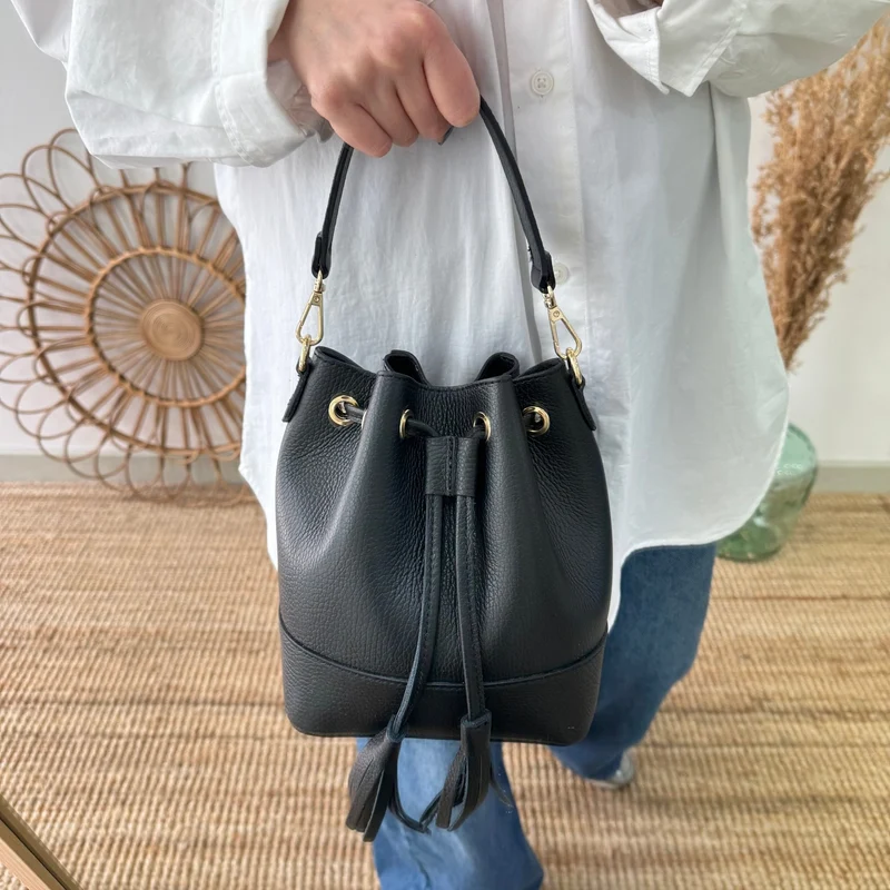 Bolso bucket piel negro pompón iniciales bordadas