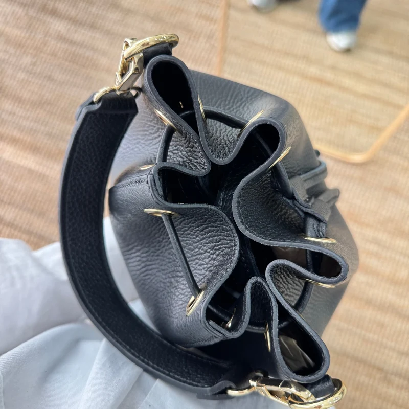 Bolso bucket piel negro pompón iniciales bordadas