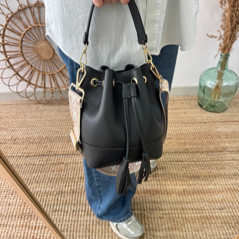 Bolso bucket piel negro pompón iniciales bordadas