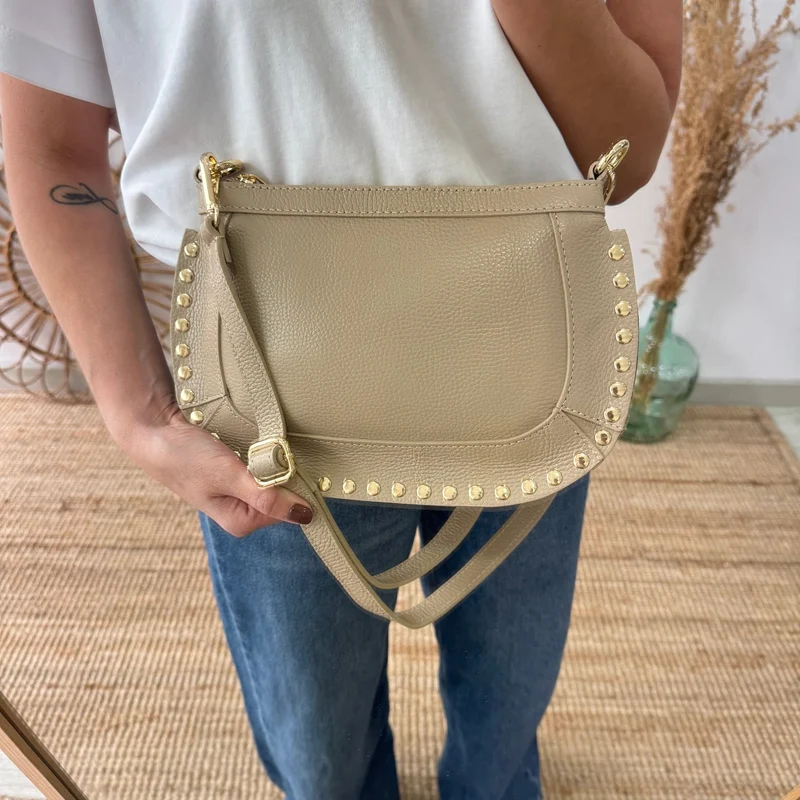 Bandolera ovalada piel tachuelas taupe iniciales bordadas
