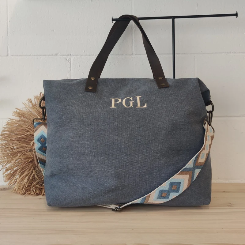 Bolso azul loneta iniciales bordadas con correa étnica